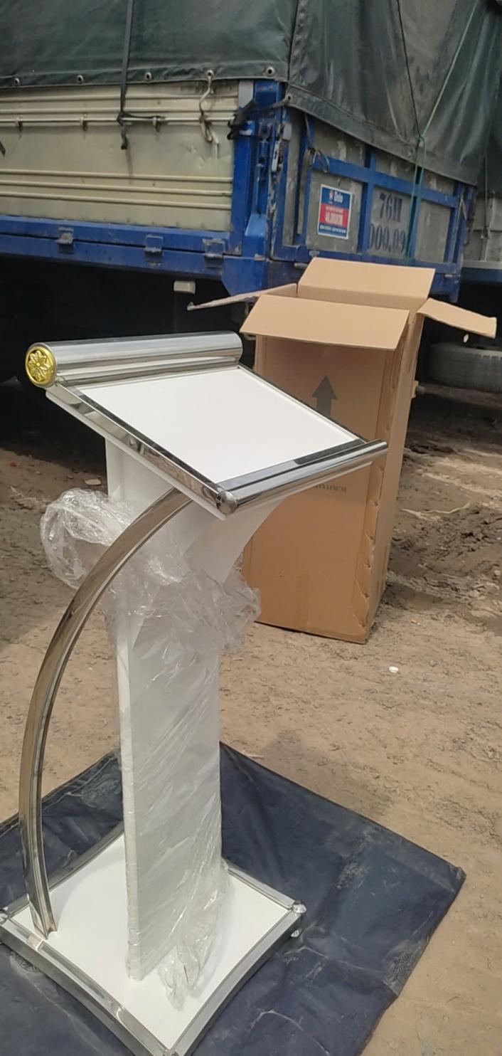 Một chiếc bục phát biểu bằng gỗ thanh lịch trong hội trường hiện đại, thể hiện vai trò trung tâm của nó.