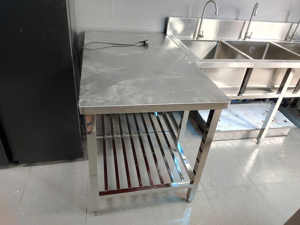 Infographic thể hiện 4 yếu tố chính ảnh hưởng đến giá thành bàn bếp inox: Chất liệu, Kích thước, Độ dày, Gia công.