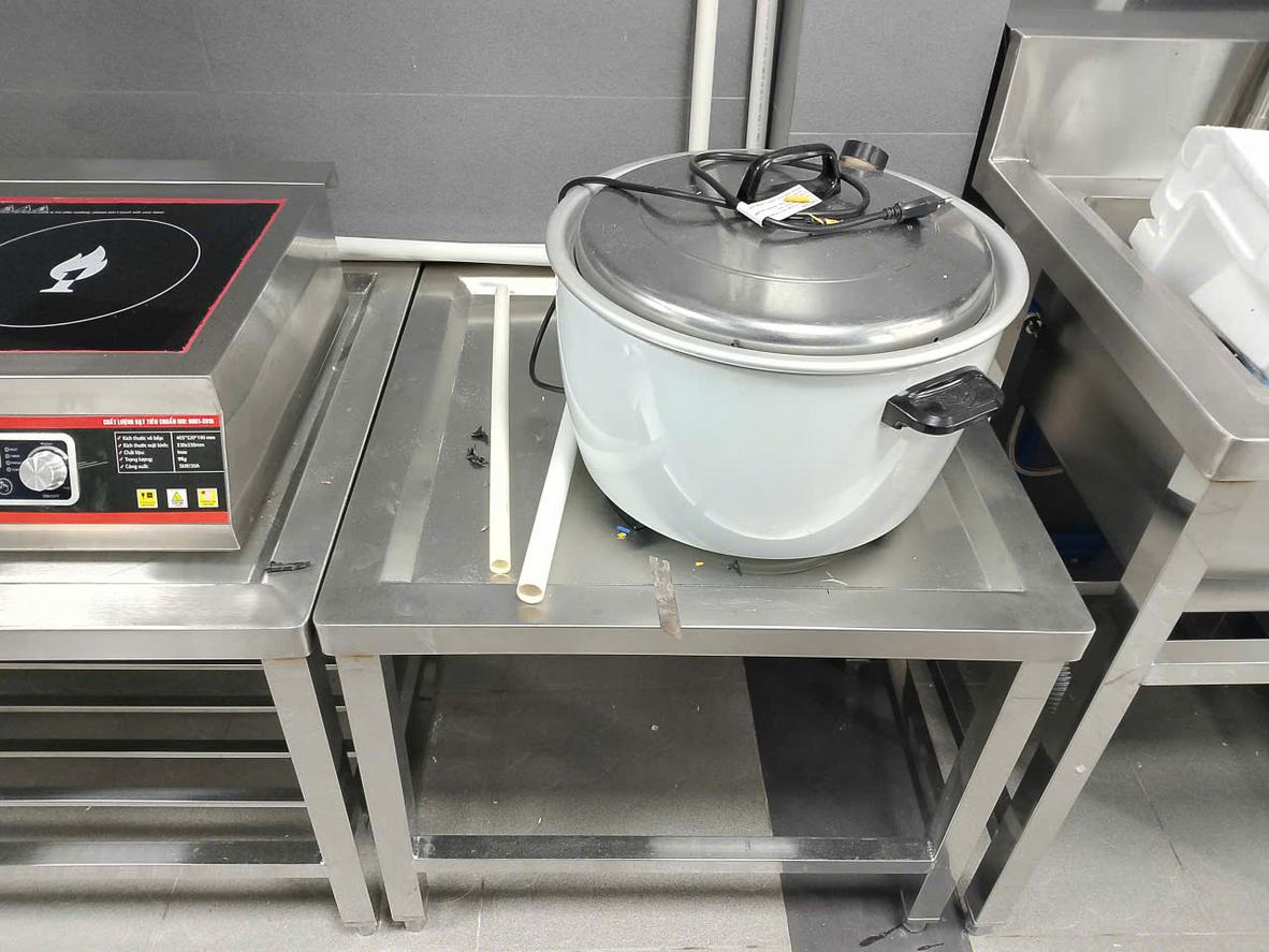 Hình ảnh nhân viên kỹ thuật đang đo đạc không gian bếp để tư vấn kích thước bàn inox cho khách hàng.