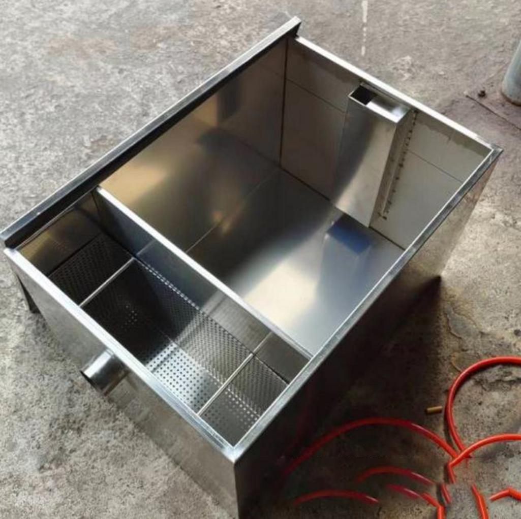 Hình ảnh kỹ thuật viên đang lắp đặt một bể tách mỡ inox, thể hiện sự chuyên nghiệp.