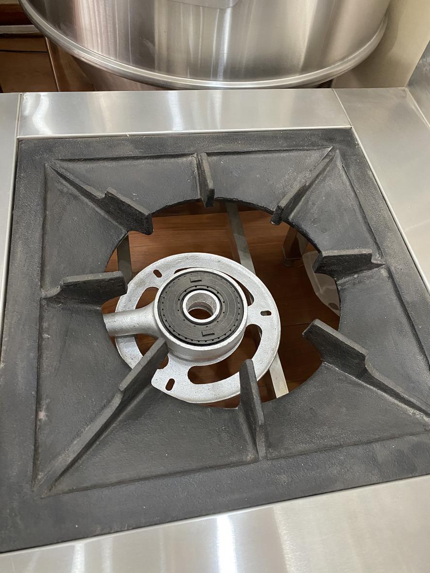 Kỹ thuật viên đang kiểm tra rò rỉ gas trên hệ thống đường ống của bếp hầm công nghiệp.