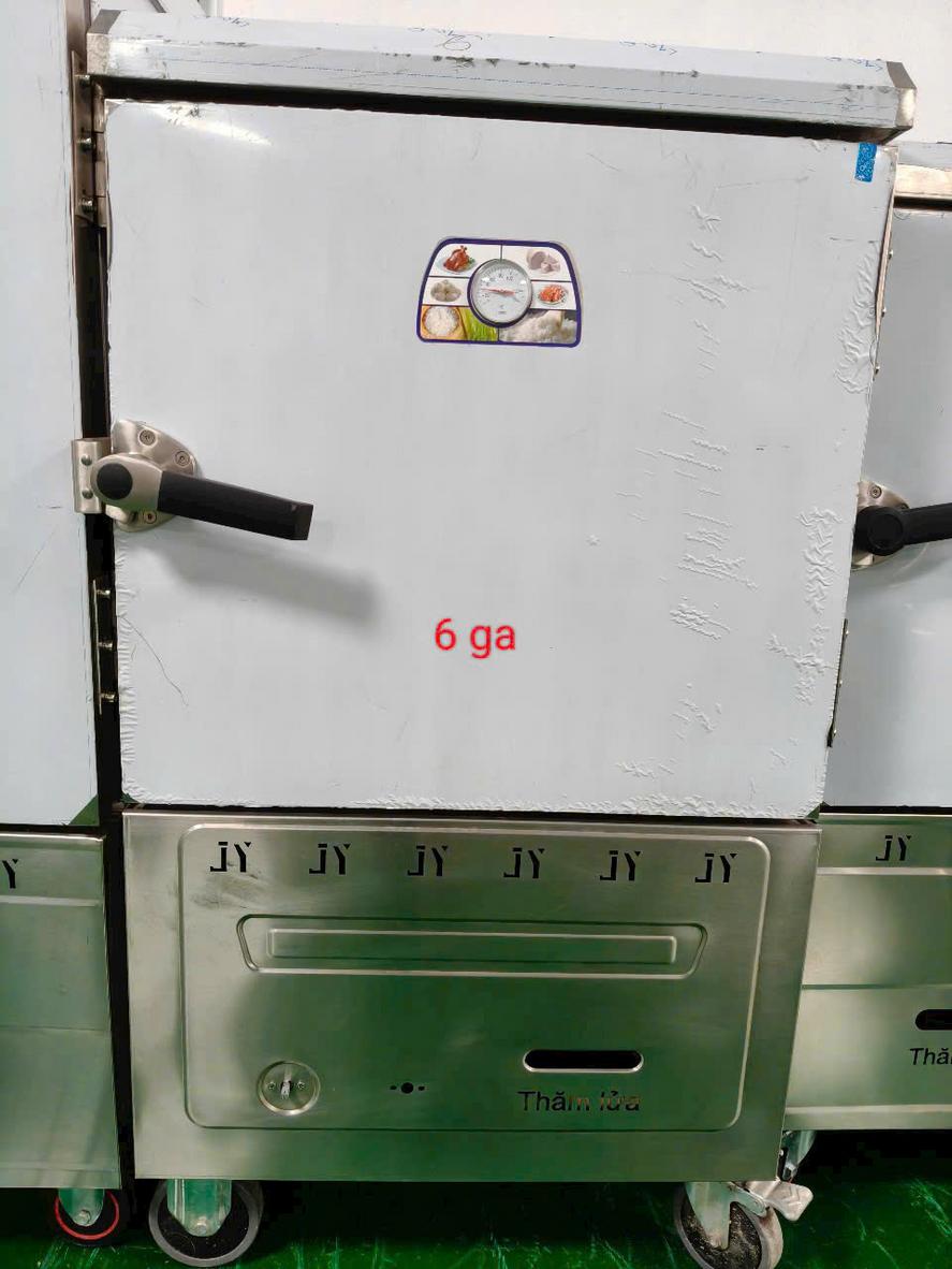 Nhân viên bếp thực hiện công đoạn vệ sinh tủ hấp hải sản bằng dung dịch chuyên dụng và khăn mềm.