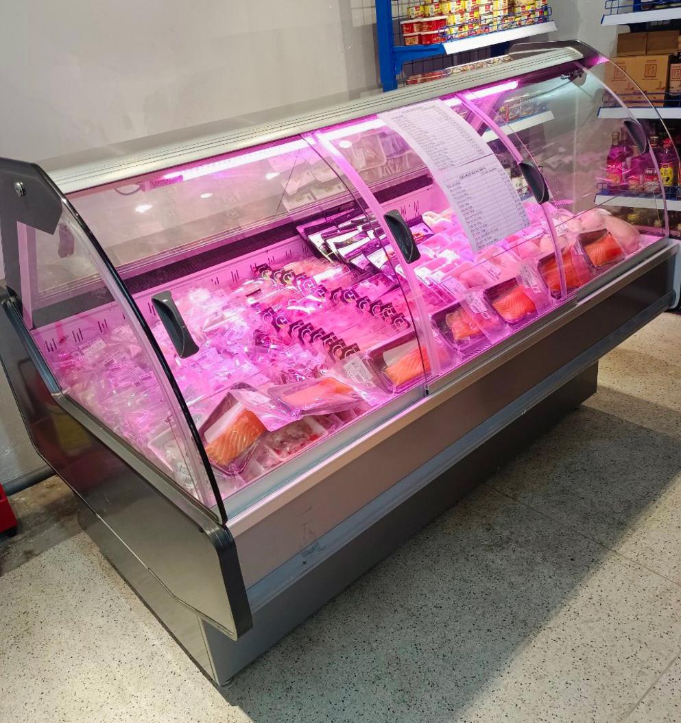 Nhân viên tư vấn đang giải thích các mức giá khác nhau của tủ trưng bày cho khách hàng.