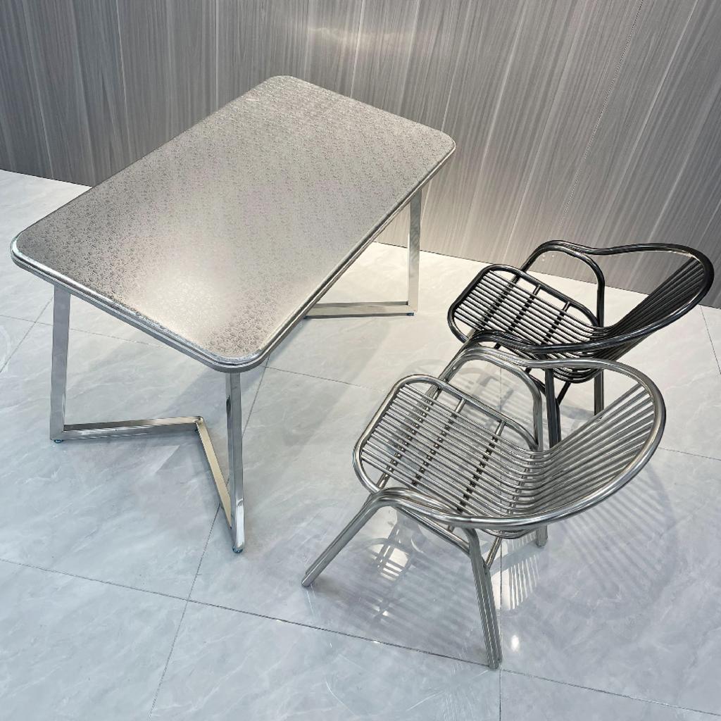 Một chuyên gia đang tư vấn cho khách hàng về các mẫu bàn ghế inox tại xưởng.