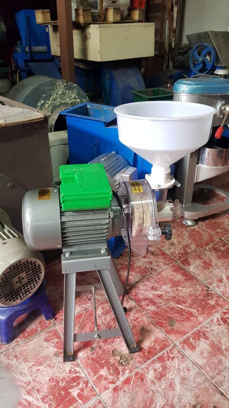 Hình ảnh kỹ thuật viên đang hướng dẫn khách hàng vận hành máy xay bột đúng cách.