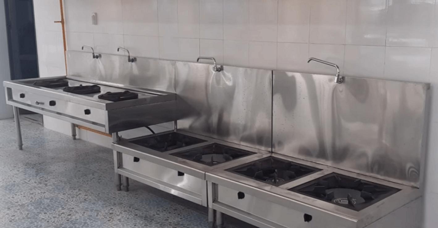 Nhân viên đang thực hiện vệ sinh bếp hầm đôi inox 304 sau ca làm việc.