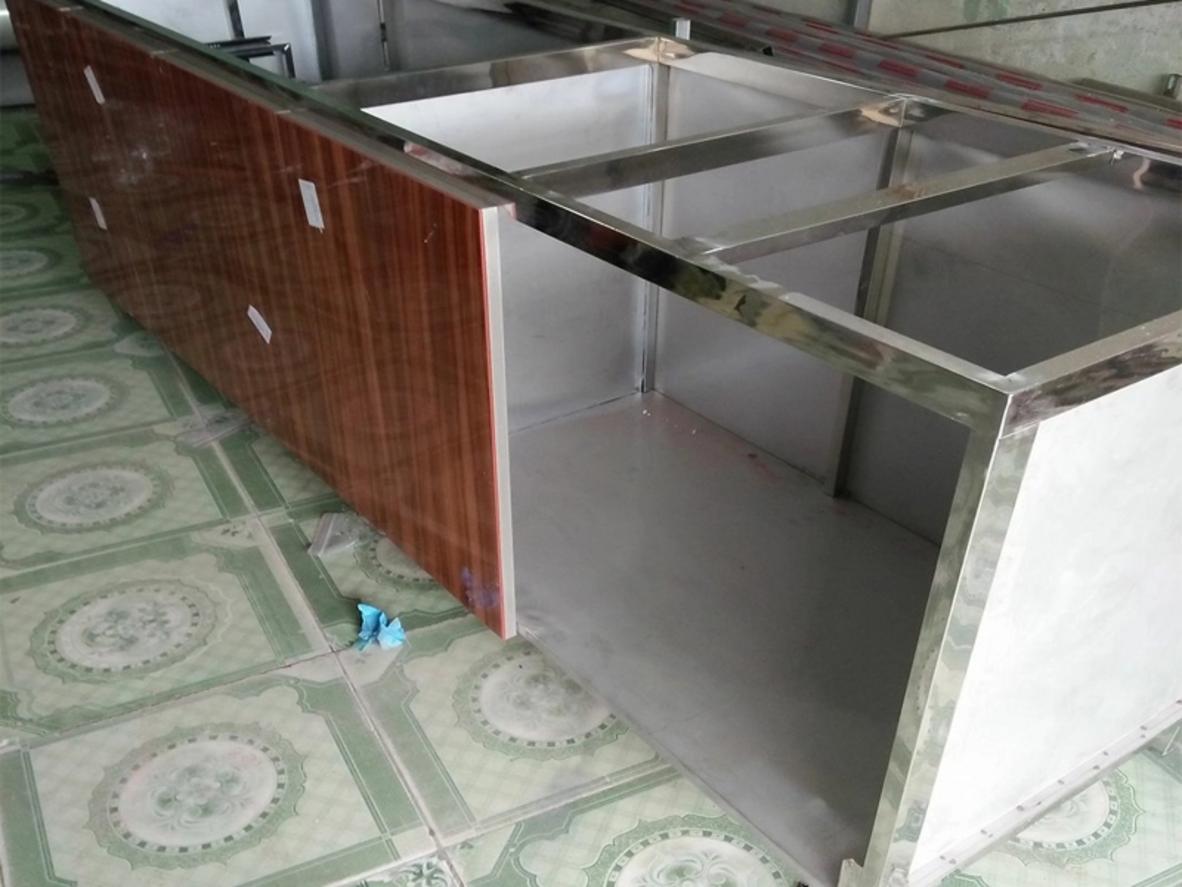 Kỹ thuật viên kiểm tra vật liệu inox trước khi gia công tủ bếp theo yêu cầu.